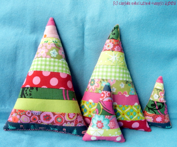 Fabric Christmas trees. Triangles made of narrow horizontal stripes in pink and green colours.