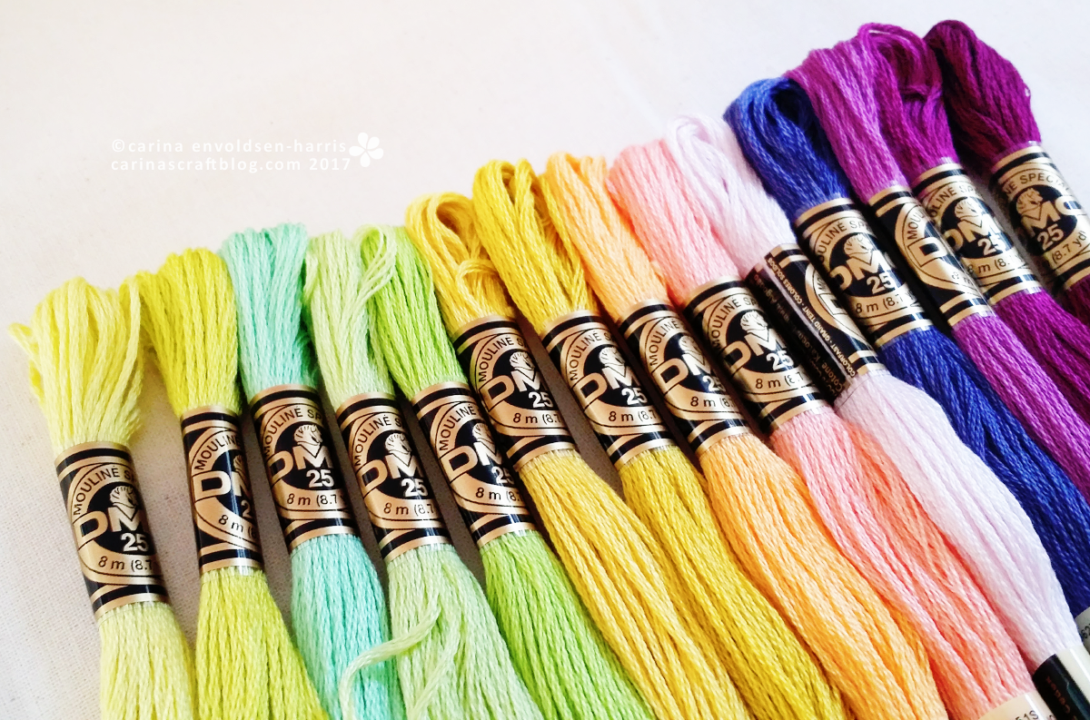 Skeins of embroidery thread in yellow, green and purple.