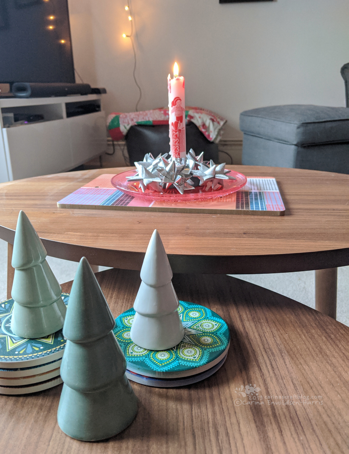 Coffee table with ceramic Christmas trees and an advent candle.