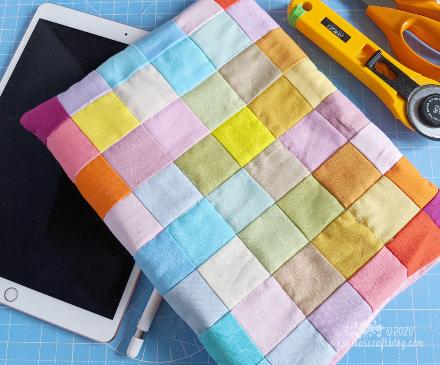 Patchwork cover with squares in pastel colours placed on an ipad.