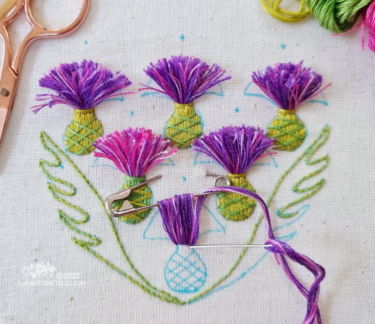 Embroidered thistles on white fabric,.