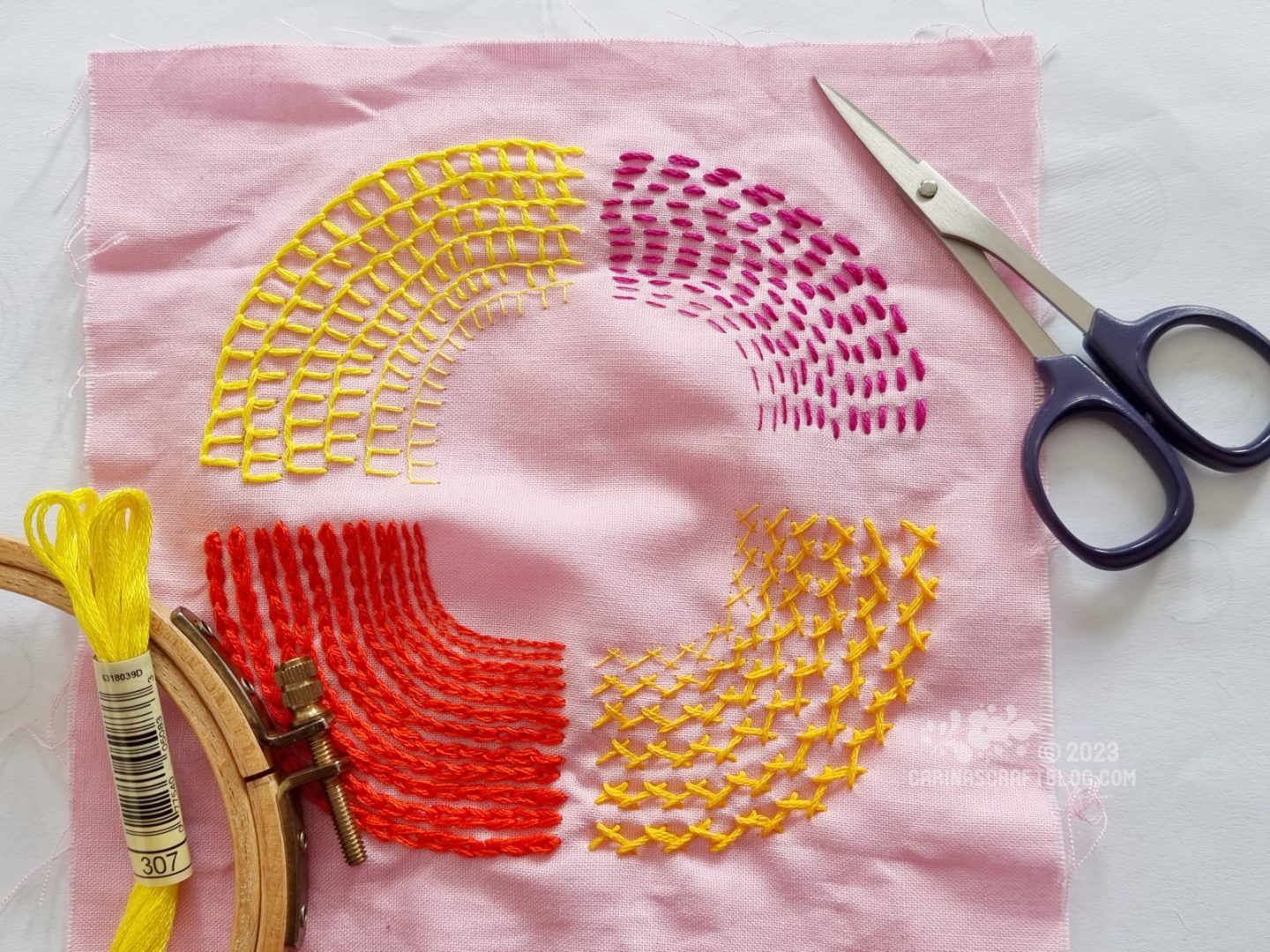 Light pink fabric with four sections stitched in quarter circles, using different thicknesses of thread.