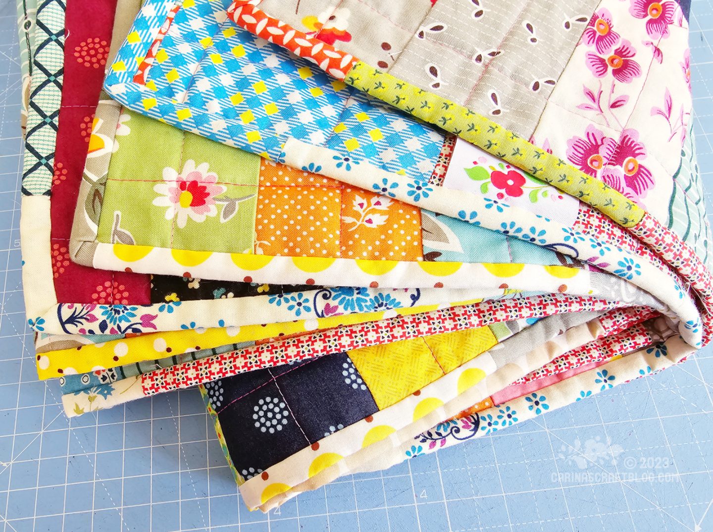 Close view of a rolled quilt, showing the multi coloured binding.