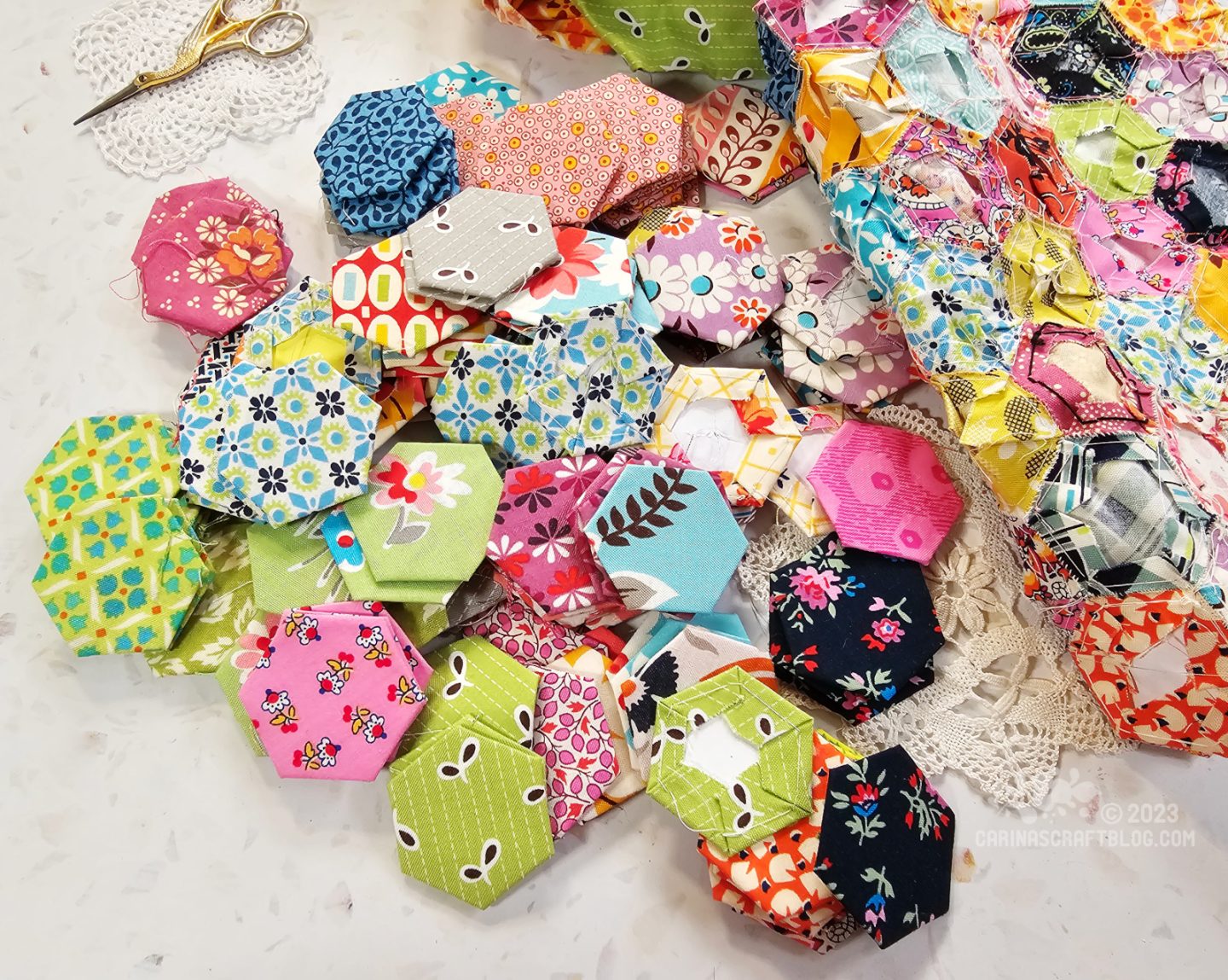 Overhead view of a scattered pile of fabric hexagons.
