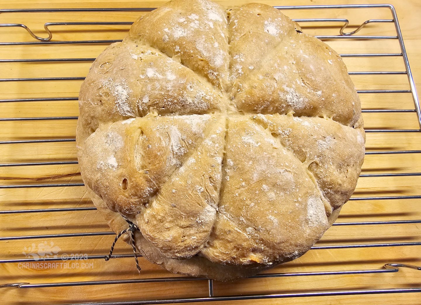 View from above of a round loaf of bread with four lines across it that divides it into eight segments.