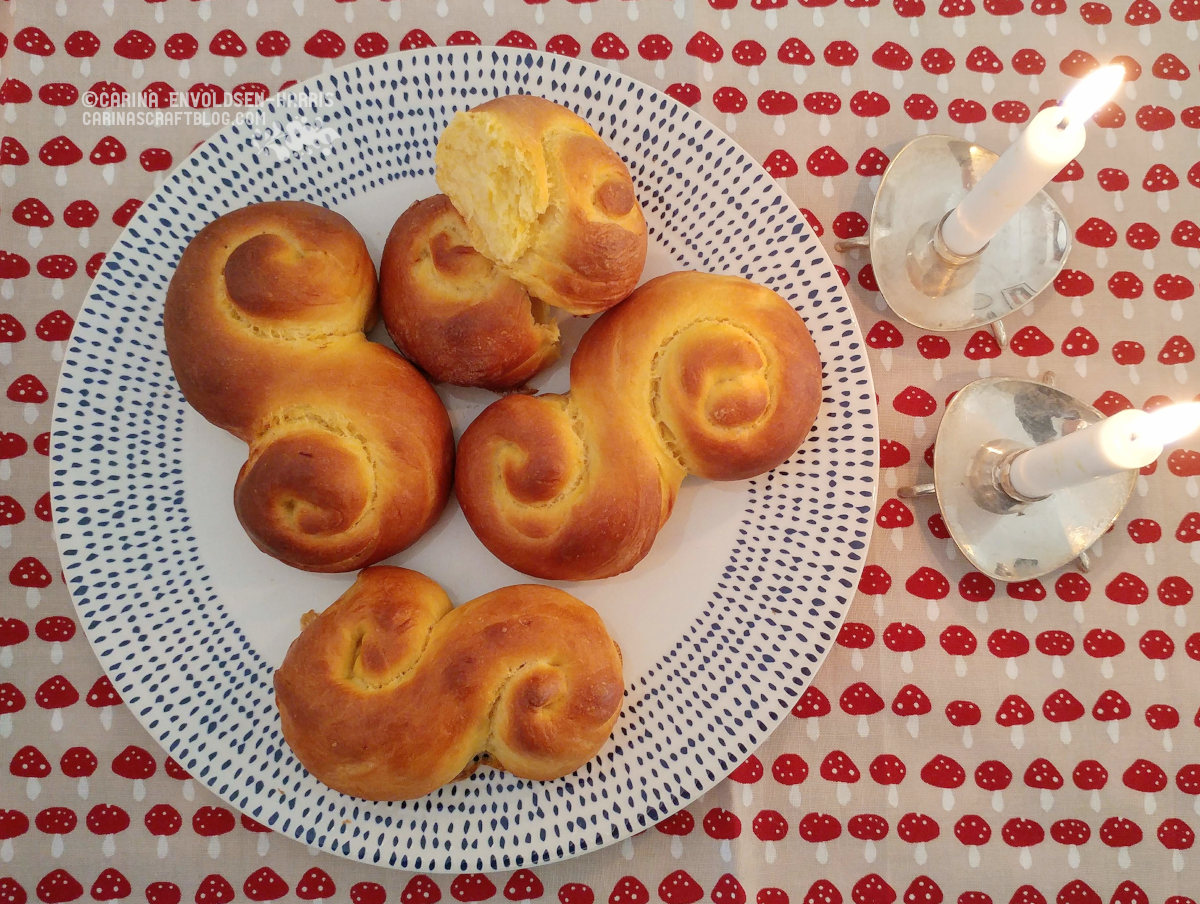 Overhead view of a white plate with blue decoration along the edge. The plate is filled with S shaped yellow buns.