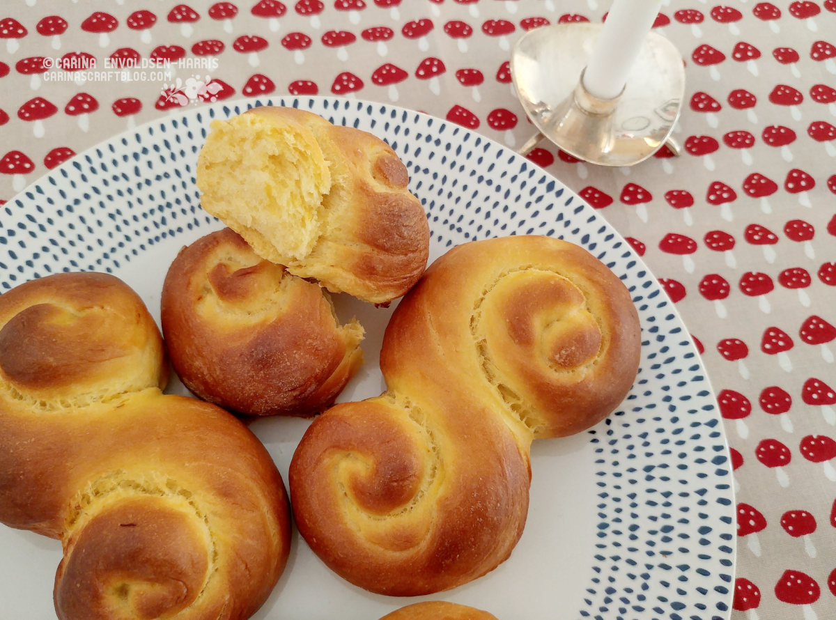 Partial view of a white plate with shaped yellow saffron buns.