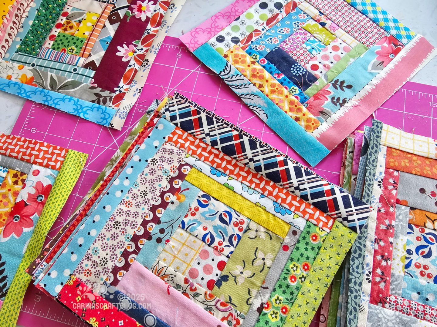 Photo. Overhead view of quilt blocks made from strips in many different prints and colours.